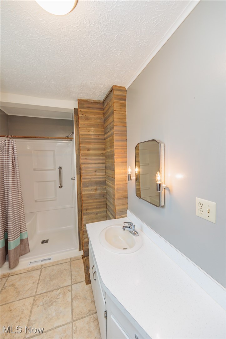 1866 Alpha Road Greenwich, OH 44837 - Photo 20 of 50 Bathroom featuring vanity, a textured ceiling, walk in shower, and tile patterned flooring