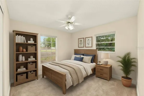 a bedroom with a bed a bookshelf and a potted plant