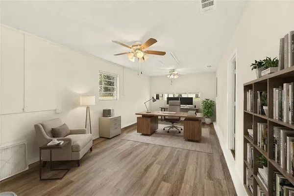 a living room with furniture and a wooden floor