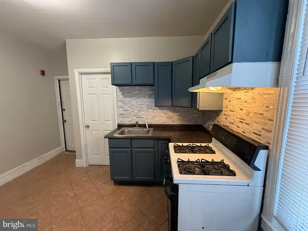 a kitchen with granite countertop a stove and a refrigerator