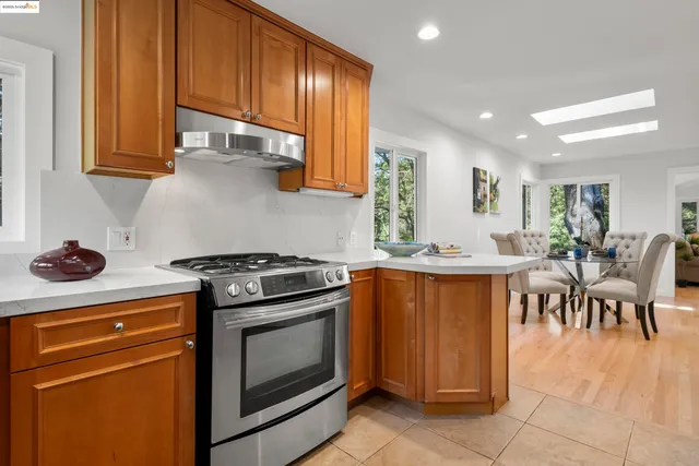 a kitchen with stainless steel appliances granite countertop a stove top oven a sink dishwasher and cabinets with wooden floor