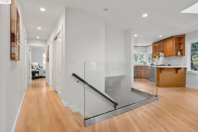 a view of a kitchen with kitchen island wooden floors stainless steel appliances and a window