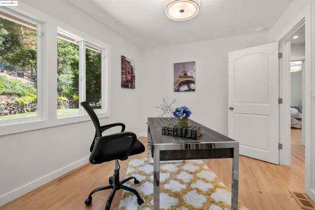 a view of a workspace with furniture and a window