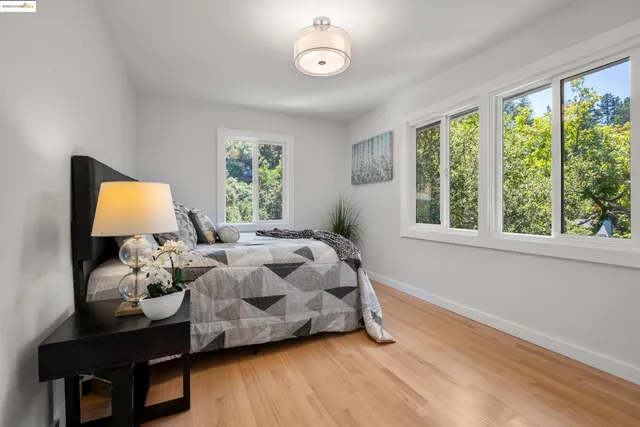 a bedroom with a bed mirror and window