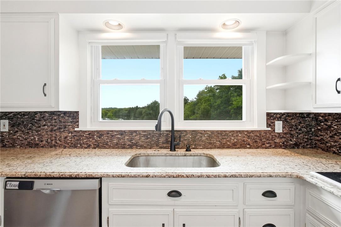 463 North Penn Dixie Road Bath, PA 18014 - Photo 17 of 86 A well-appointed kitchen features a stainless steel sink set in stone counters beneath bright windows.