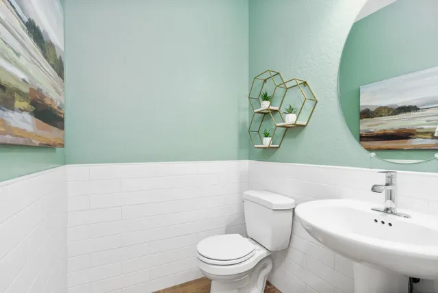 a bathroom with a sink a toilet and mirror