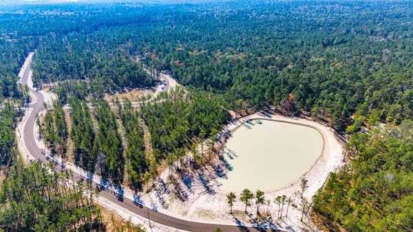 a view of a swimming pool with a yard and trees