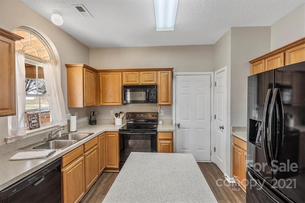 3919 Faith Church Road Indian Trail, NC 28079 - Photo 11 of 34 a kitchen with stainless steel appliances a sink stove refrigerator and cabinets