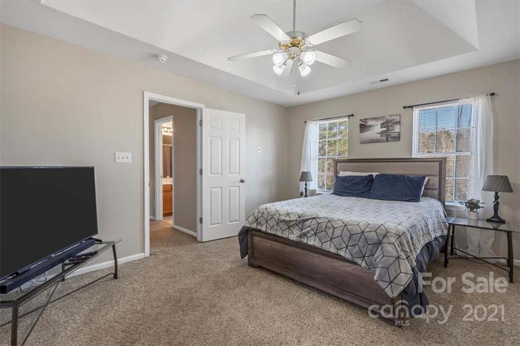 3919 Faith Church Road Indian Trail, NC 28079 - Photo 17 of 34 a spacious bedroom with a bed and a flat screen tv
