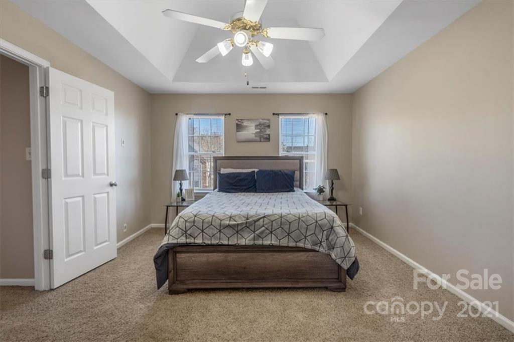 3919 Faith Church Road Indian Trail, NC 28079 - Photo 18 of 34 a bedroom with a bed and a chandelier