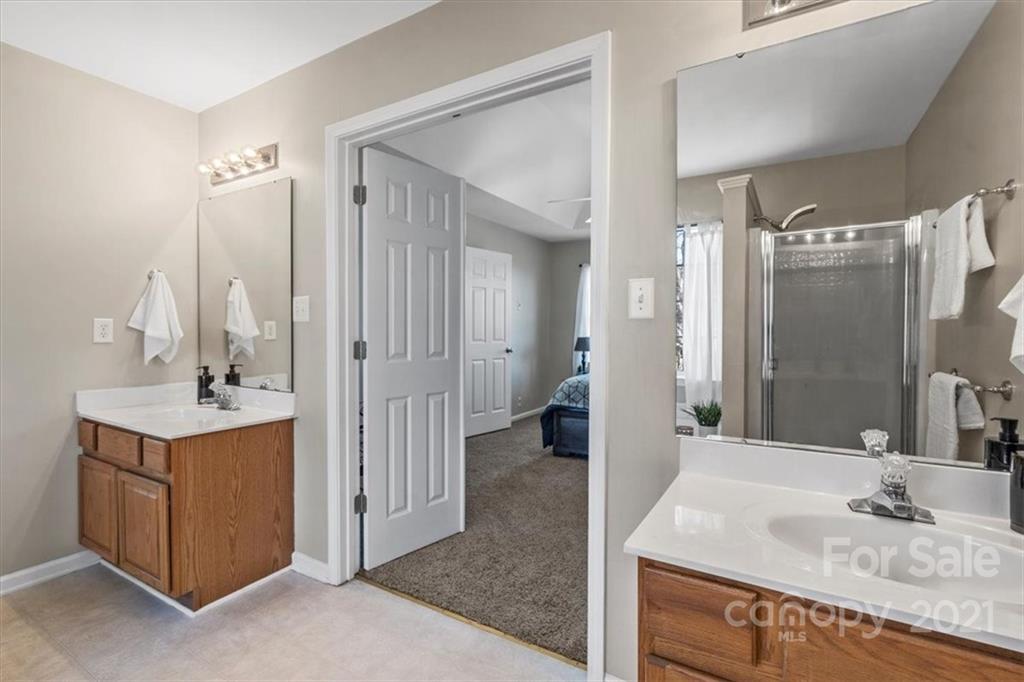 3919 Faith Church Road Indian Trail, NC 28079 - Photo 22 of 34 a bathroom with a granite countertop sink a mirror and shower