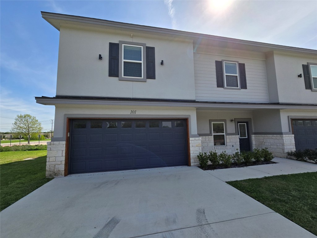 a front view of a house with a garden and yard
