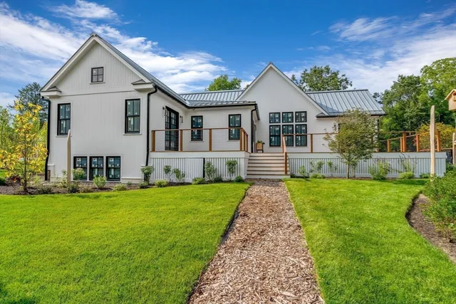 a front view of a house with a yard and trees