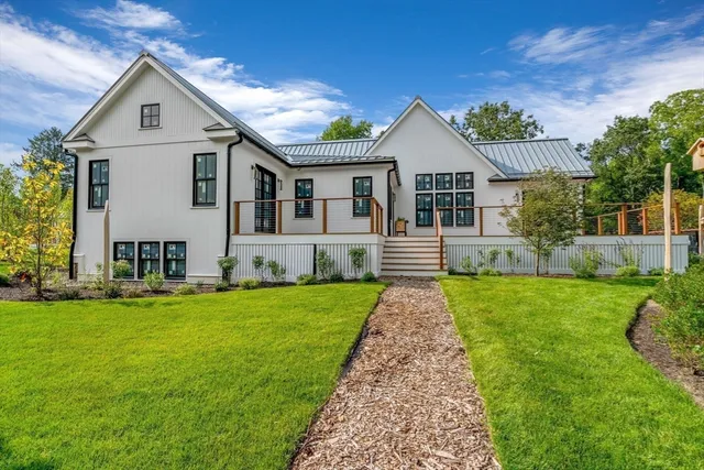 a front view of a house with a yard and trees