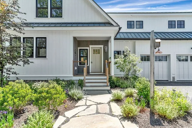 a view of a house with a yard and potted plants