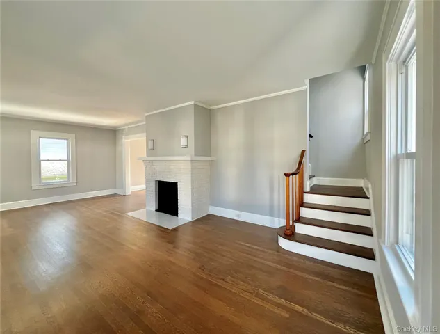 an empty room with a fireplace and wooden floor