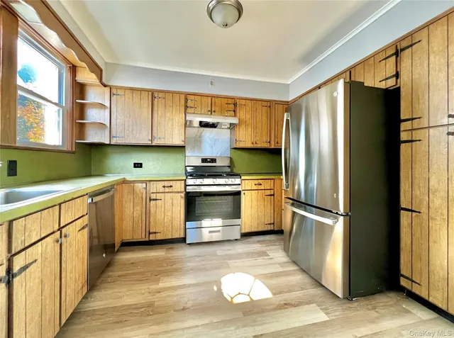 a kitchen with granite countertop a refrigerator and a sink