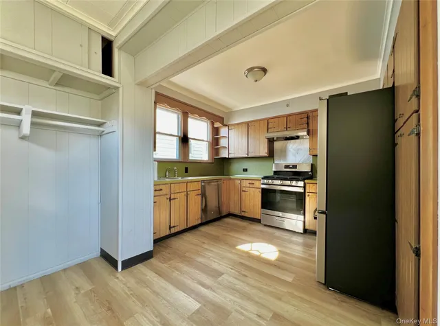 a kitchen with stainless steel appliances a refrigerator and a stove top oven