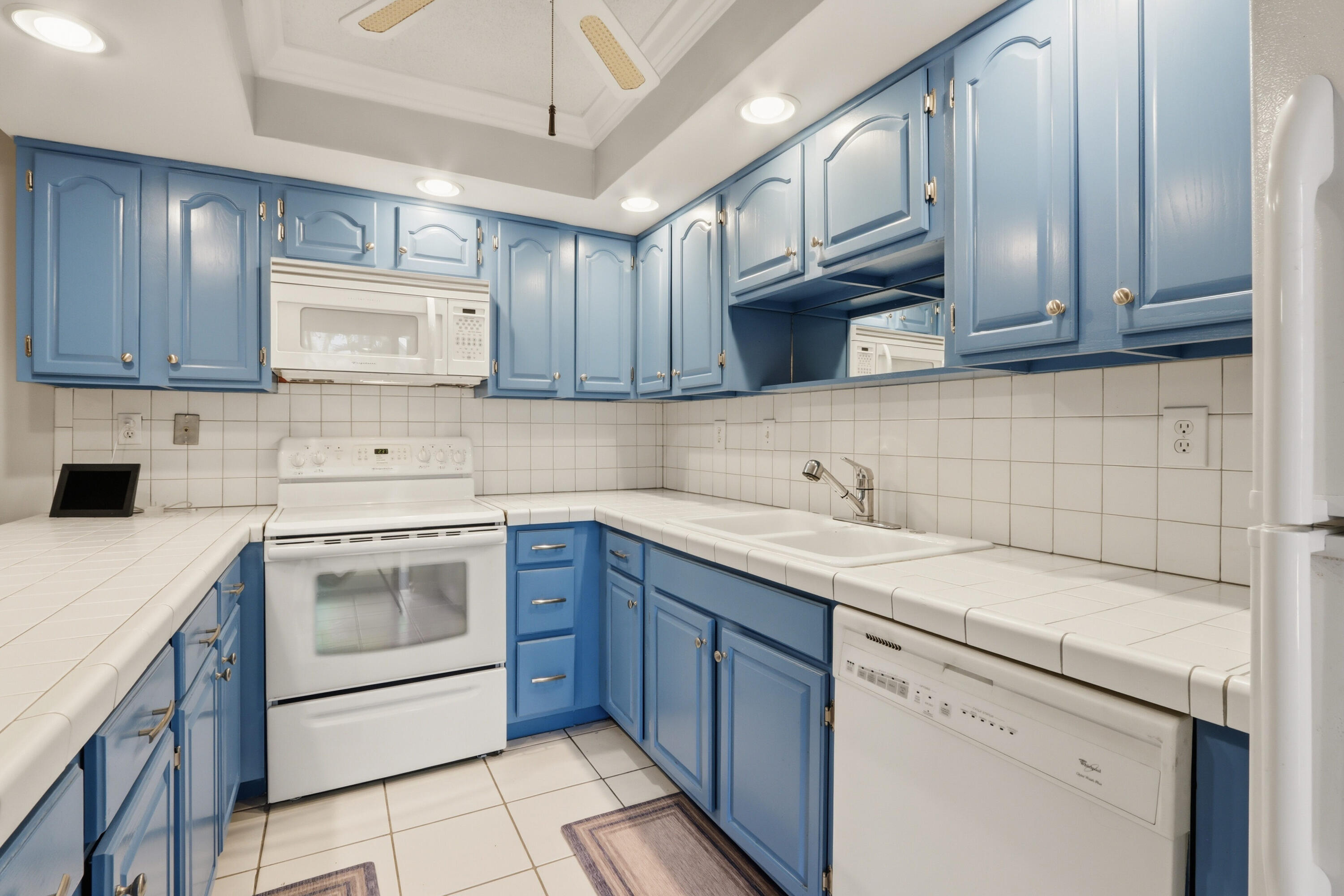 9 Atrium Circle, Unit C Atlantis, FL 33462 - Photo 14 of 54 a kitchen with a sink stove and cabinets