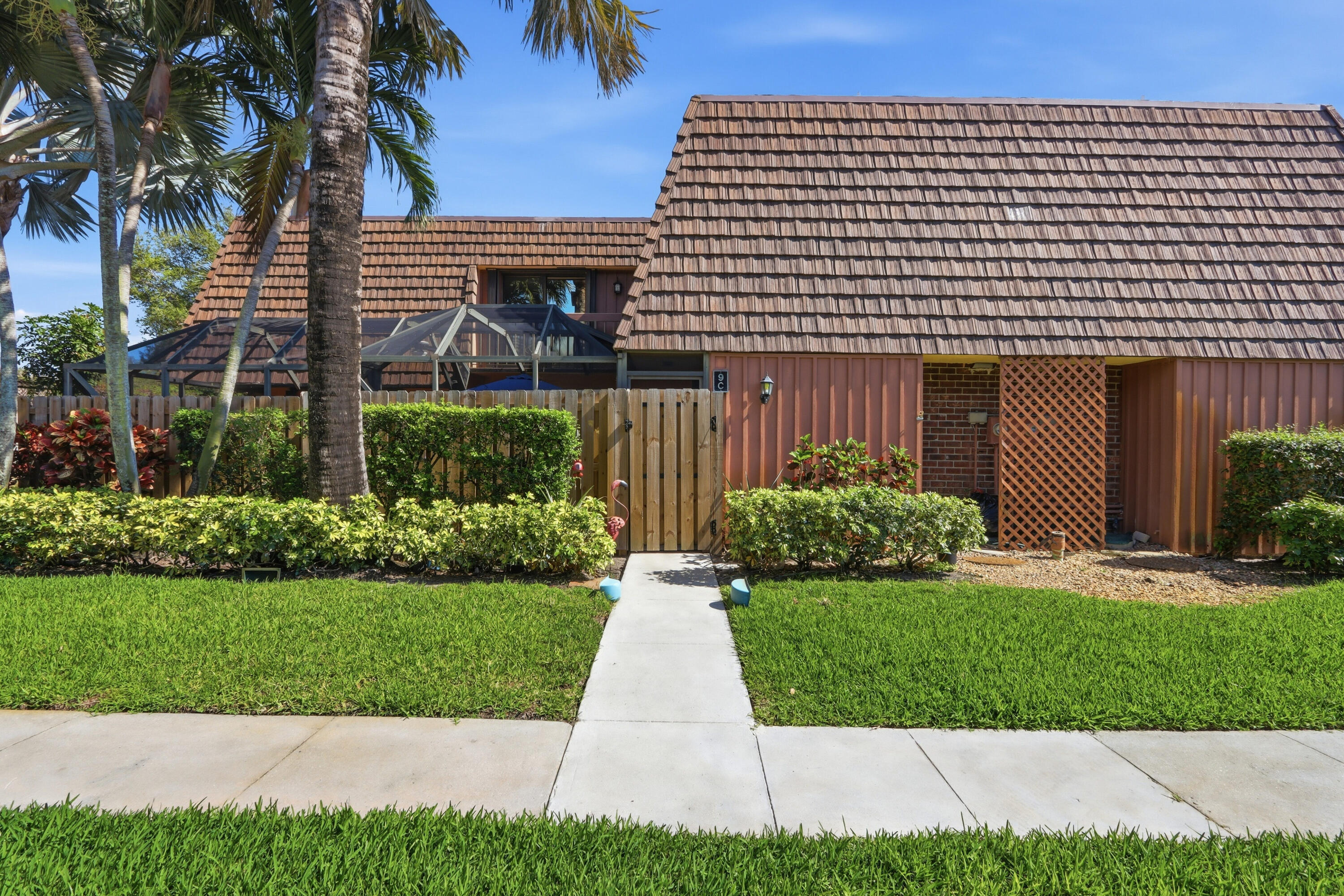 9 Atrium Circle, Unit C Atlantis, FL 33462 - Photo 31 of 54 a front view of a house with a yard