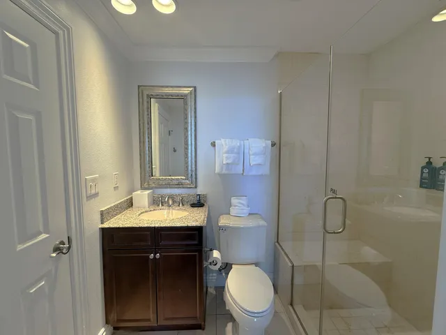 a bathroom with a sink vanity mirror and toilet