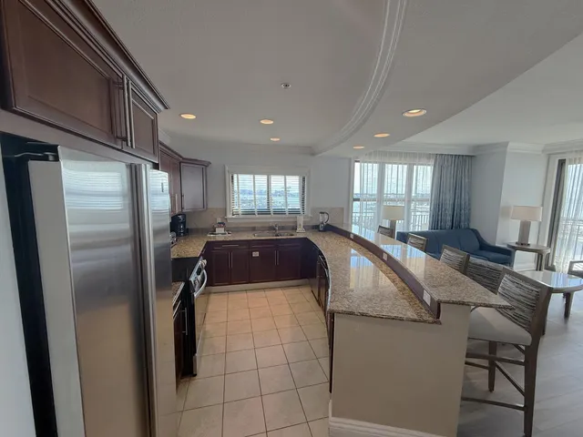 a kitchen with stainless steel appliances granite countertop a refrigerator a sink dishwasher and a refrigerator