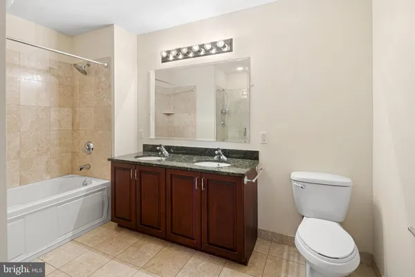 a bathroom with a sink a toilet a mirror and shower