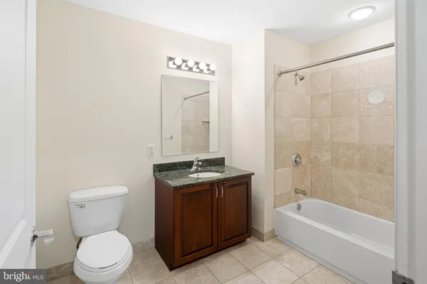 a bathroom with a granite countertop toilet a sink and bathtub