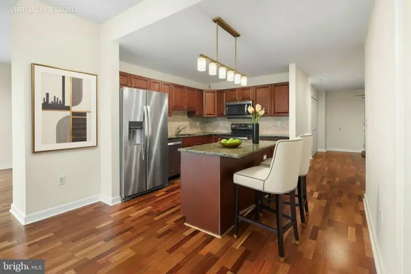 a kitchen with stainless steel appliances wooden floor and dining table