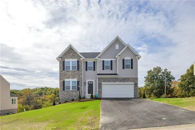 a front view of a house with a yard and garage