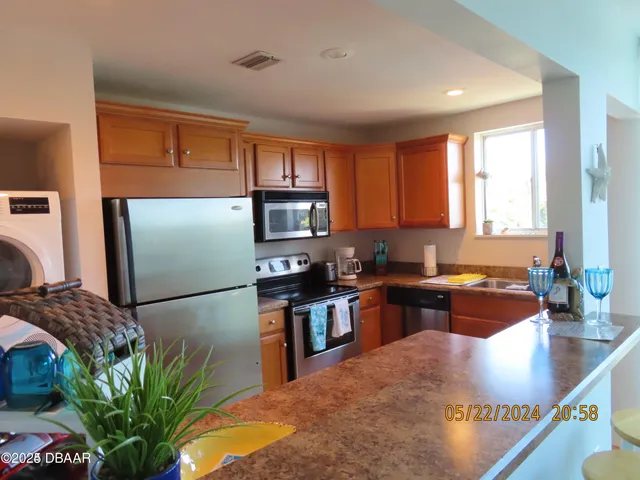 a kitchen with stainless steel appliances granite countertop sink stove refrigerator and microwave