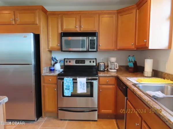 a kitchen with stainless steel appliances granite countertop a refrigerator stove top oven a sink and dishwasher