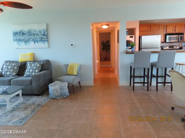 a living room with furniture and kitchen space