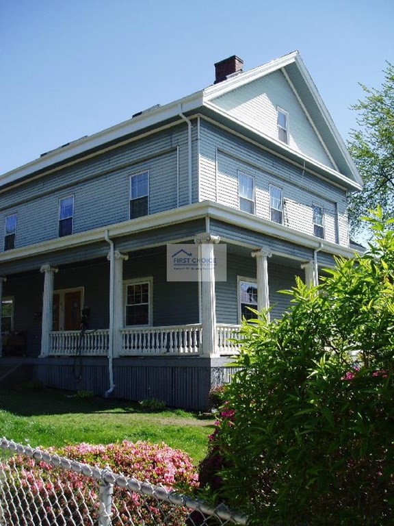 a front view of a house with a garden and plants