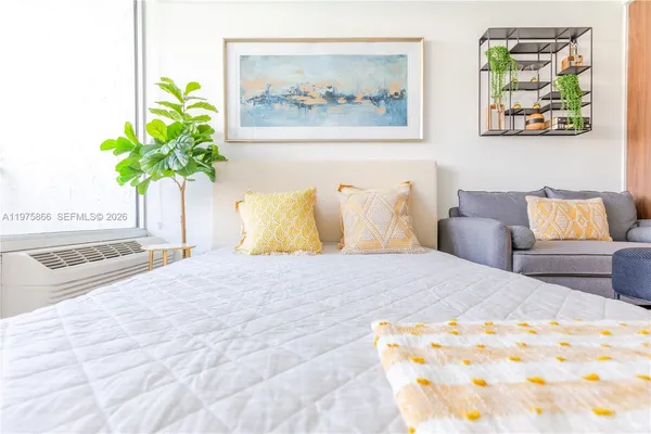 a bedroom with a bed and a painting on the wall