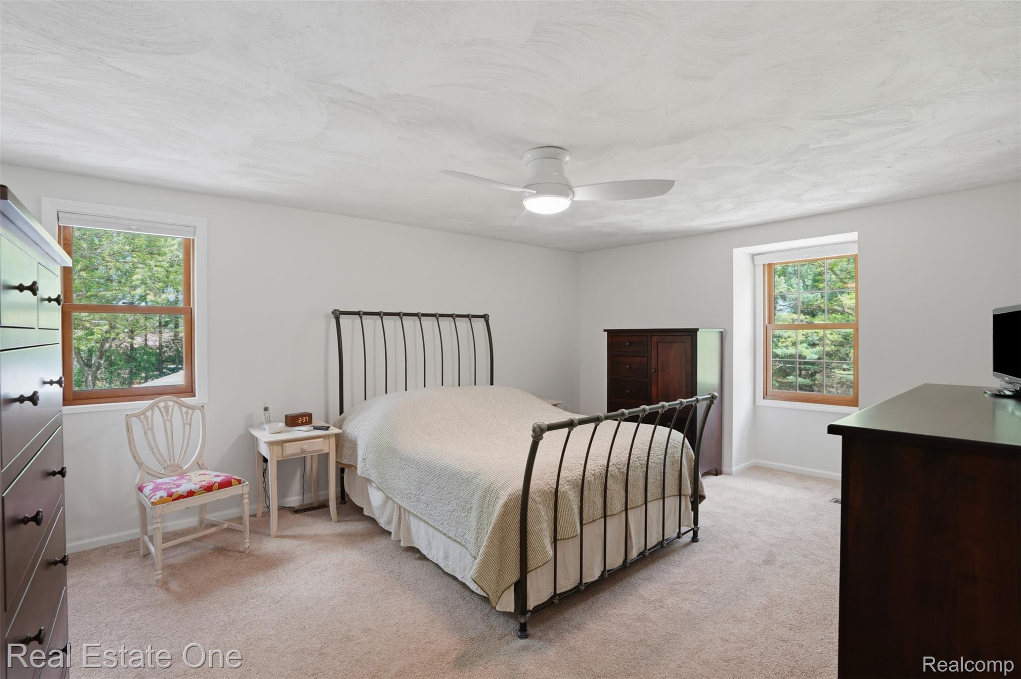 1765 Rowe Road Milford, MI 48380 - Photo 27 of 61 Carpeted room featuring a ceiling fan with integrated lighting, two windows with wood trim, and light-toned walls