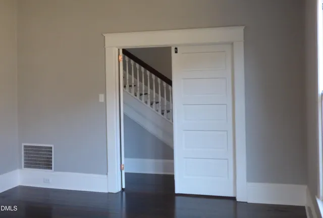 an empty room with wooden floor sink and closet