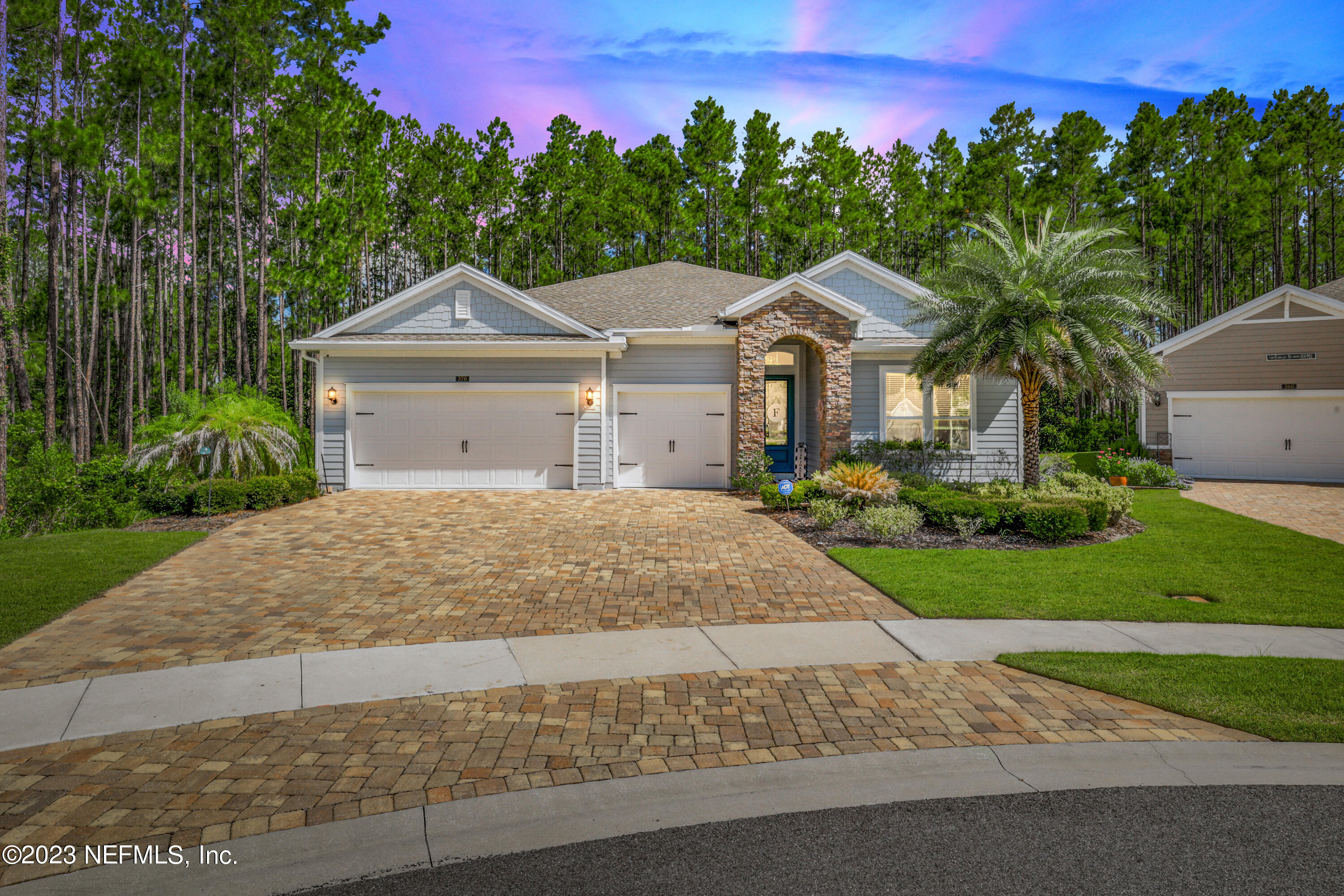 a front view of a house with a yard and trees