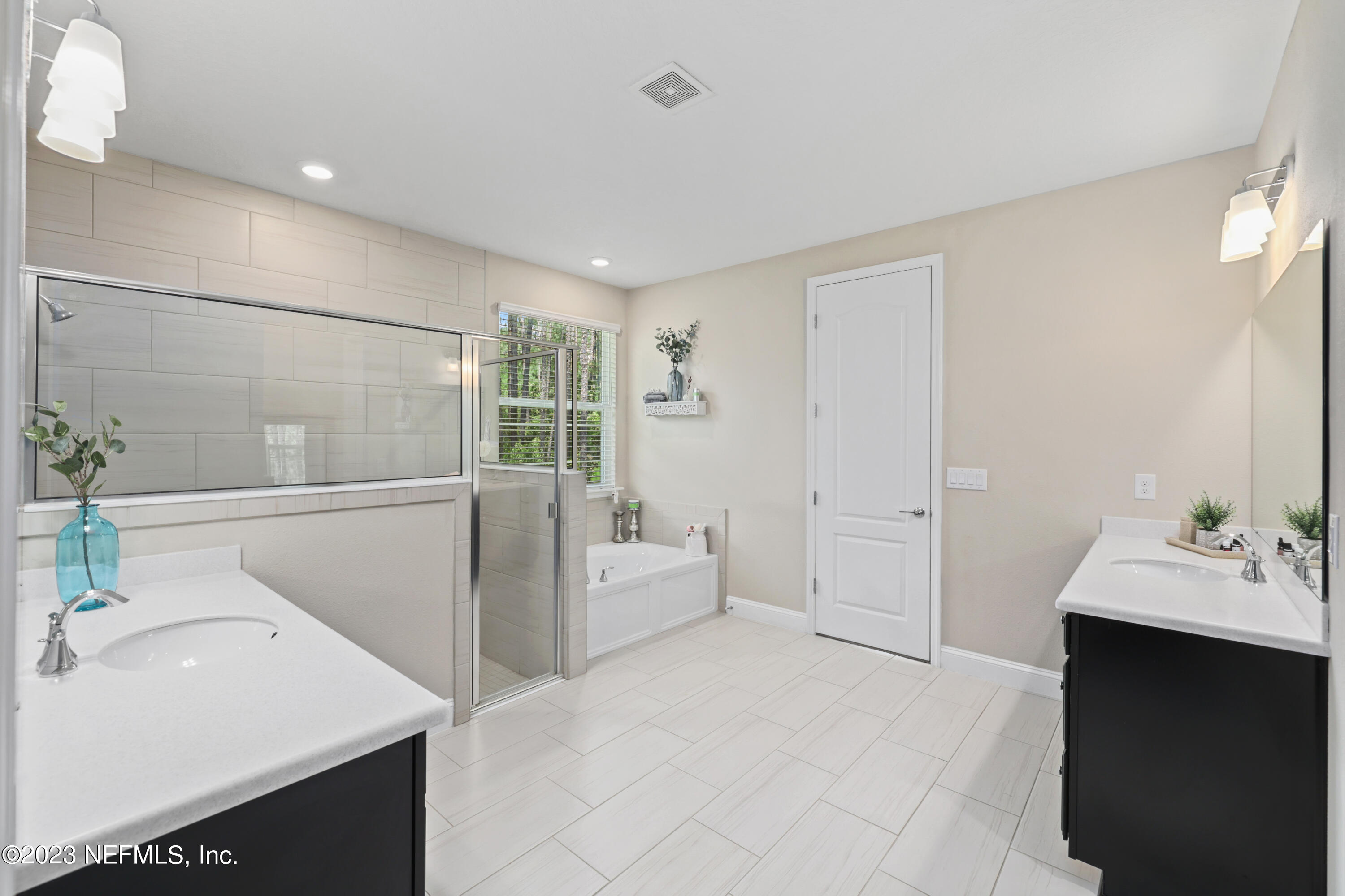 370 Coco Point St. Augustine, FL 32092 - Photo 21 of 48 a en suite bathroom with a double vanity sink a large mirror and shower