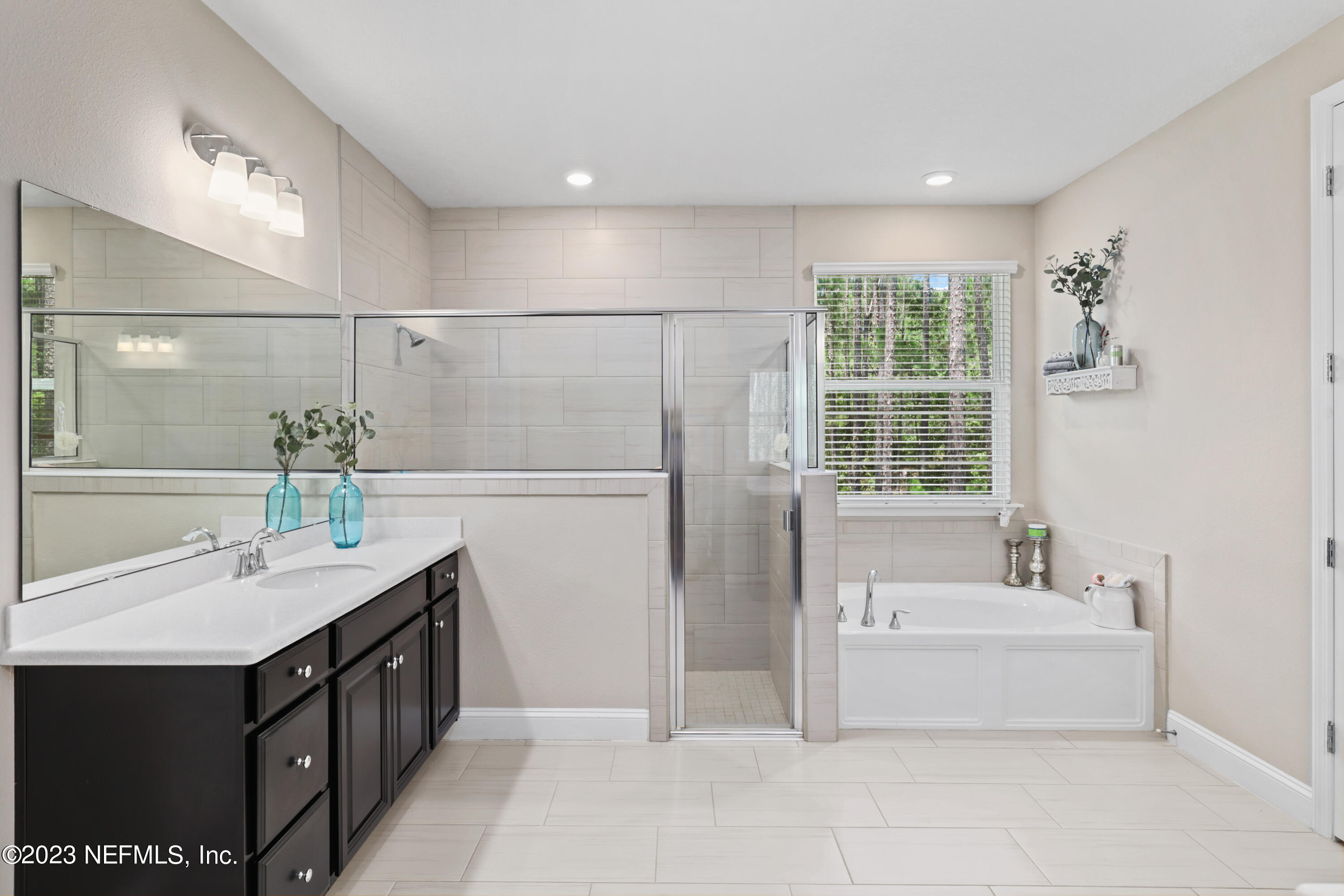 370 Coco Point St. Augustine, FL 32092 - Photo 22 of 48 a spacious bathroom with a double vanity sink a mirror and a bathtub