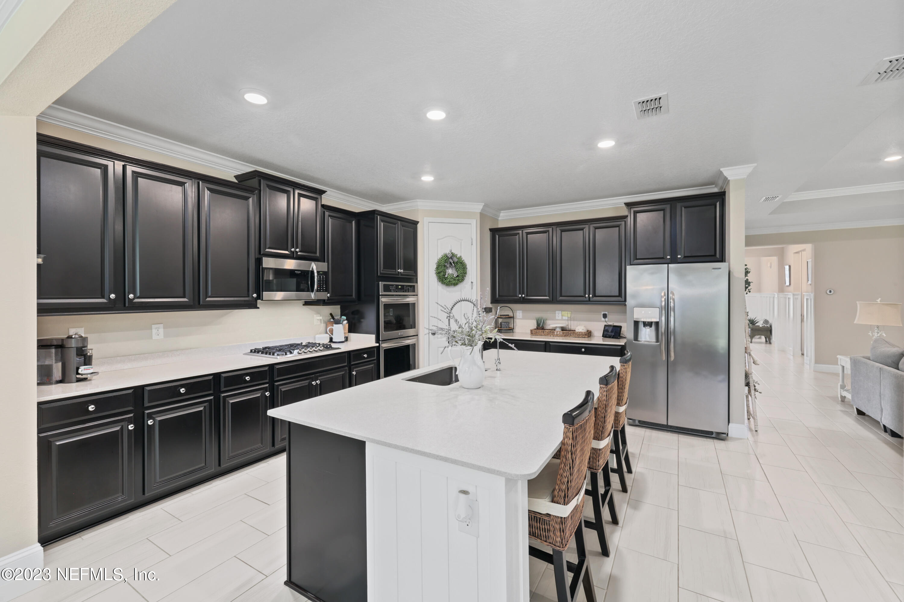 370 Coco Point St. Augustine, FL 32092 - Photo 3 of 48 a kitchen with stainless steel appliances kitchen island granite countertop a stove refrigerator and cabinets