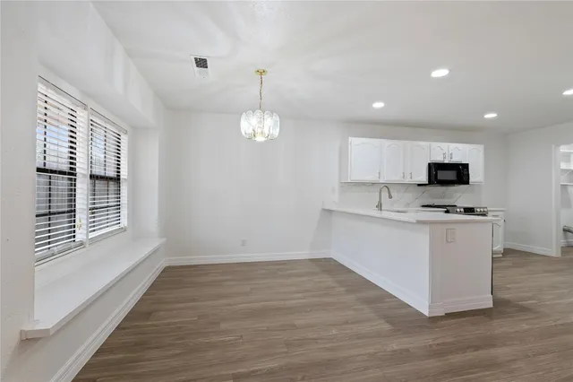 a view of kitchen with granite countertop cabinets with stainless steel appliances granite countertop sink and stove top oven