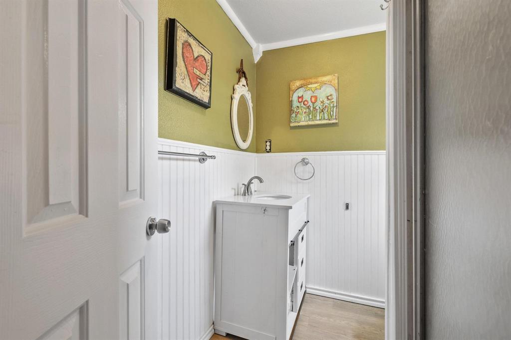 4453 Farm To Market 902 Howe, TX 75459 - Photo 33 of 40 Powder room featuring a white single-sink vanity, beadboard wainscoting, a chrome faucet, and wood-finish flooring