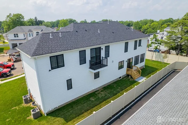 a view of empty room with wooden floor and kitchen view