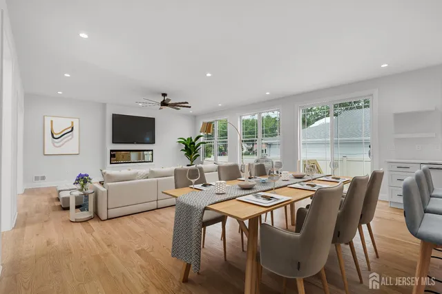 a kitchen with kitchen island granite countertop a stove a sink a dining table and chairs with wooden floor