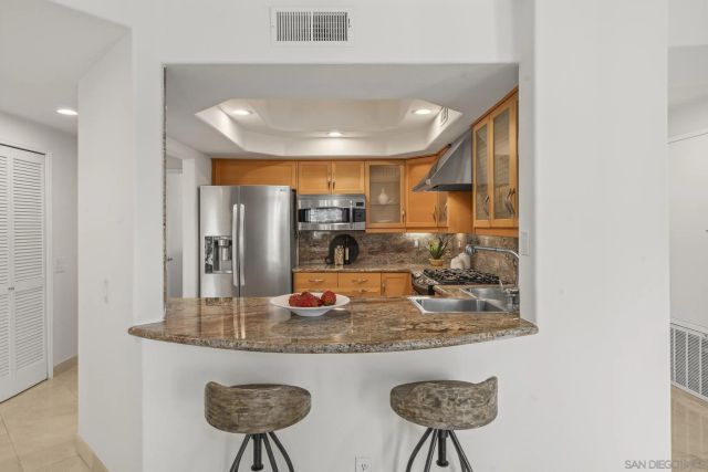 a kitchen with refrigerator and chairs