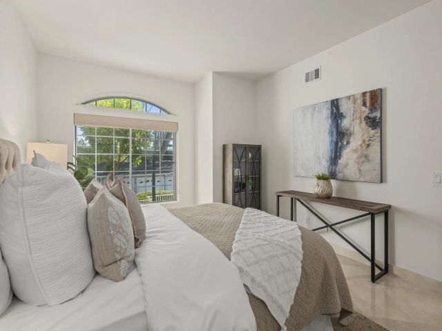 a living room with a bed furniture and a large window