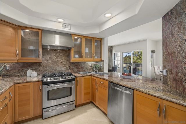a kitchen with granite countertop a sink stove and cabinets