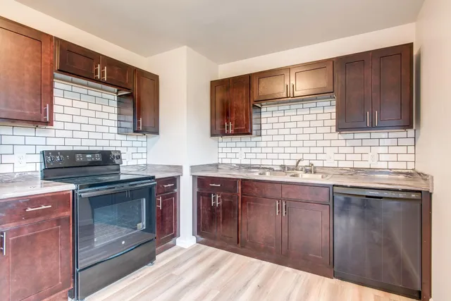 a kitchen with stainless steel appliances granite countertop a stove sink and cabinets