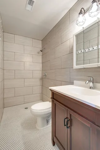 a bathroom with a sink a toilet and a mirror